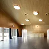 Une salle boisée de la salle des Utins, baies vitrées à gauche.